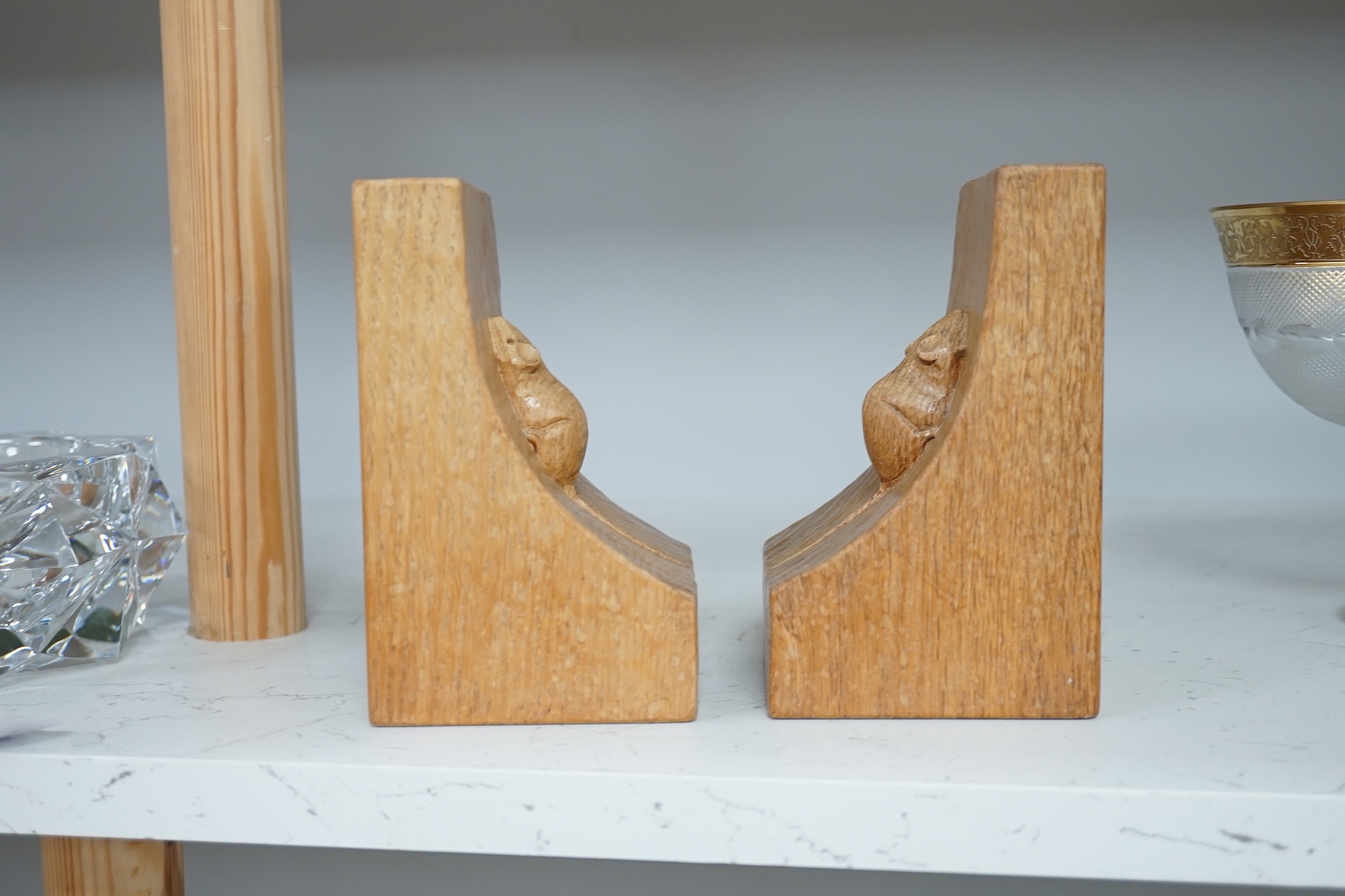 Workshop of Robert ‘’Mouseman’’ Thompson of Kilburn - a pair of English oak single mouse bookends, each with carved mouse trademark, 15cm high. Condition - good.